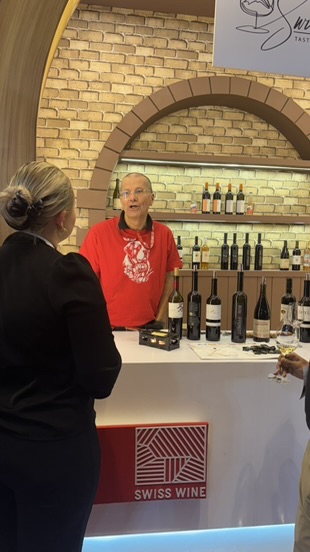Weinverkostung am Swiss-Wine-Tresen mit einem Winzer und Besucherinnen.