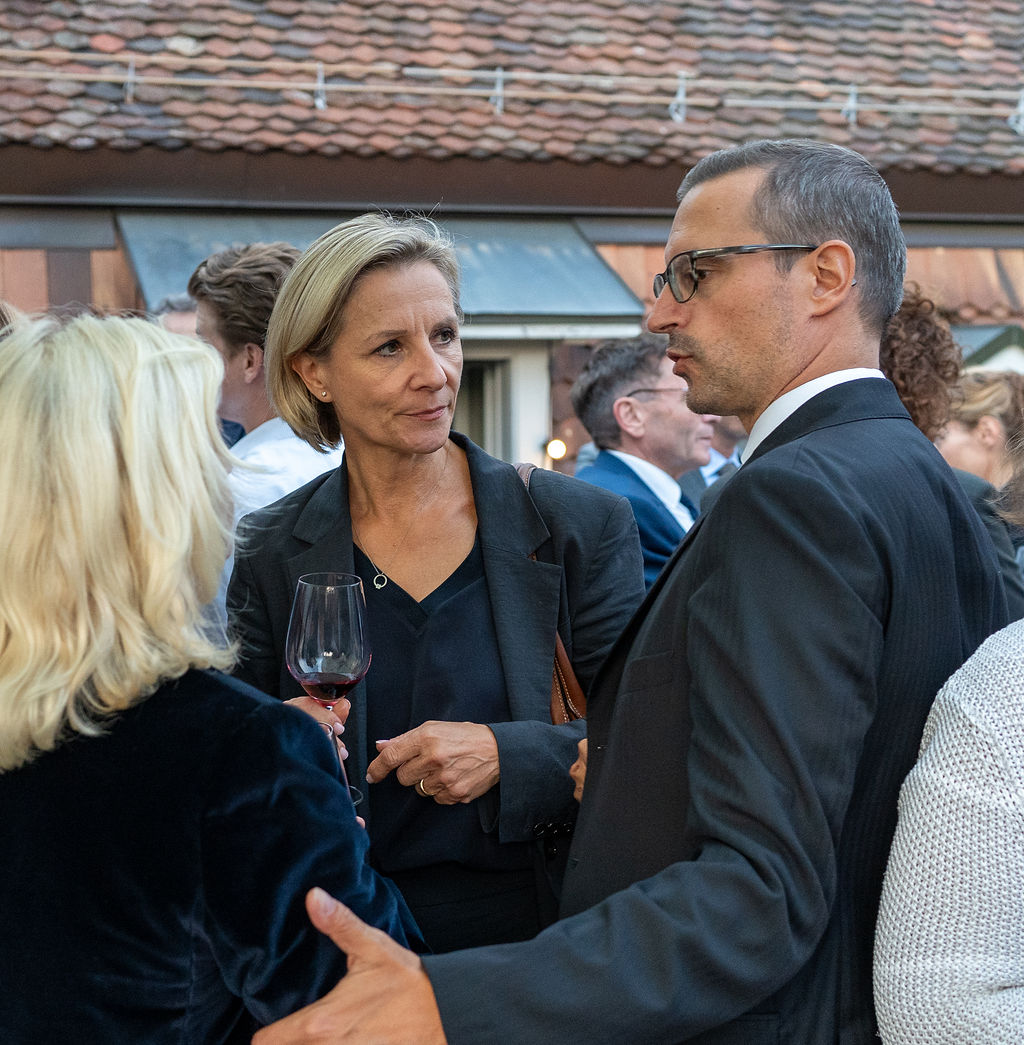 Gäste im Gespräch mit Weinglas in der Hand